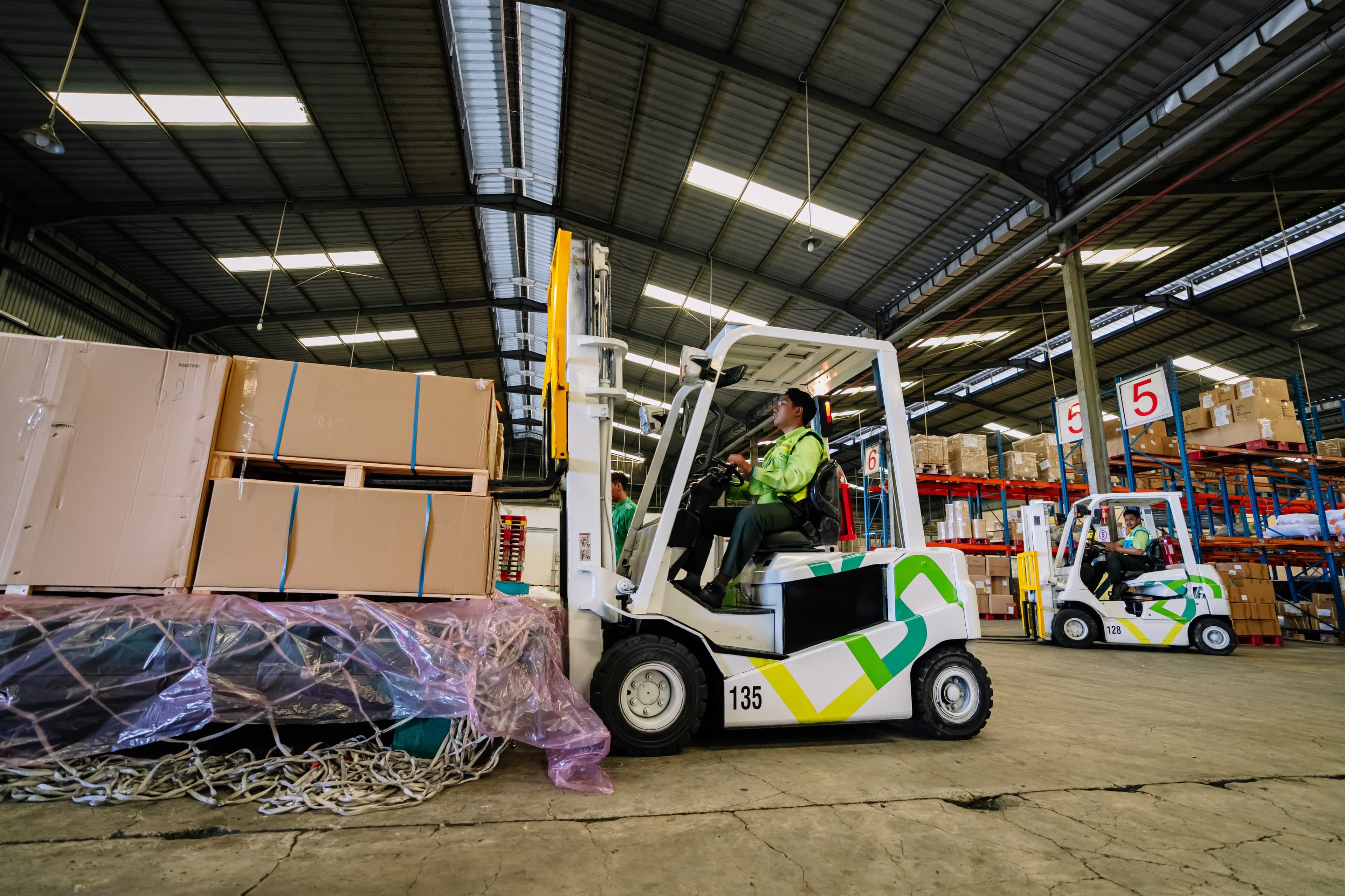 Busy logistics warehouse with forklifts and stacked cargo